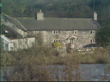 Charles moves along the riverbank behind Fenton's house