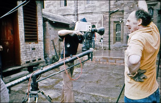 Survivors' crew members prepare to record a scene from Something of Value, with the OB camera mounted on a boom stand, in the inner courtyard of Hampton Court, some time between 5-9 June 1975. The temporary breeze-block 'dam' holds in the episode's 'flood waters'